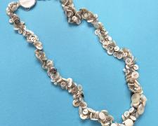 "Buttoned Up (view 2)", 2025, necklace: antique mother-of-pearl buttons, sterling, stainless steel, 9 x 9 x 1 1/2"