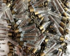 "Diamonds and Dirt" (detail), 2024, necklace: brass, glass vials, sterling, soil, cubic zirconia, diamonds, 30 x 6 x 2"