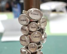 "Dirty Words" (detail), 2024, 35 rings: sterling, unknown yellow metal, glass, paper, 7 x 2 x 2"