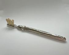 "Toothbrush", 2025, sterling, nickel, the artist's teeth, 1 x 7 x 1/2"