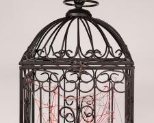 "Nested" (View 1), 2021, embroidery floss, yarn, clear cord, metal bird cage, 9 x 9 x 18"