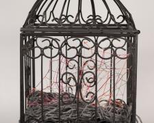 "Nested" (View 2), 2021, embroidery floss, yarn, clear cord, metal bird cage, 9 x 9 x 18"