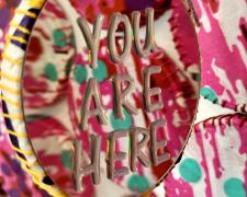 "Topographies of a Place to Know: YOU ARE HERE", 2024, installation: hand-stitched fabric, wooden hoops, mirror, letter stickers, nylon thread, stainless steel hooks, variable dimensions