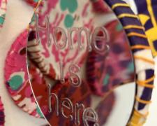 "Topographies of a Place to Know: YOU ARE HERE", 2024, installation: hand-stitched fabric, wooden hoops, mirror, letter stickers, nylon thread, stainless steel hooks, variable dimensions