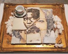"You Can't See How You See Me #2: Dr. Johnson", 2025, transfer print on poured concrete, cotton bolls, teacup and saucer, 21 x 25 x 3"