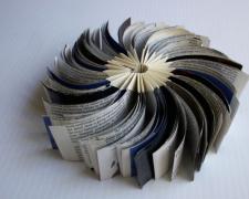 new stage, 2012, reclaimed commercial material inserted into a folded form, 2 x 4" closed / 2 x 8" open