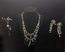"Bud Vase" (shown with "Rain' necklace and "Splash" earrings), 2024, stickpin: UV resin, monofilament, sterling silver, brass, nickel, 6 x 2 x 1/8"