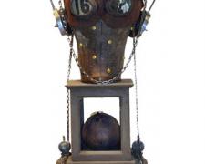 Azazel's Wife, 2007, wood construction, canvas head, headphones, chain, photo, leather mask, map pins, vials, metal parts, croquet ball, insect, number card, farm implement, curtain tie, glass, 26 x 9 x 9"