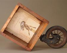 The Short Life of Karl Heck 2006 Assemblage - wood box, piano wheel, book pages, squirrel skull 11 1/4 x 16 1/2 x 5 3/4"